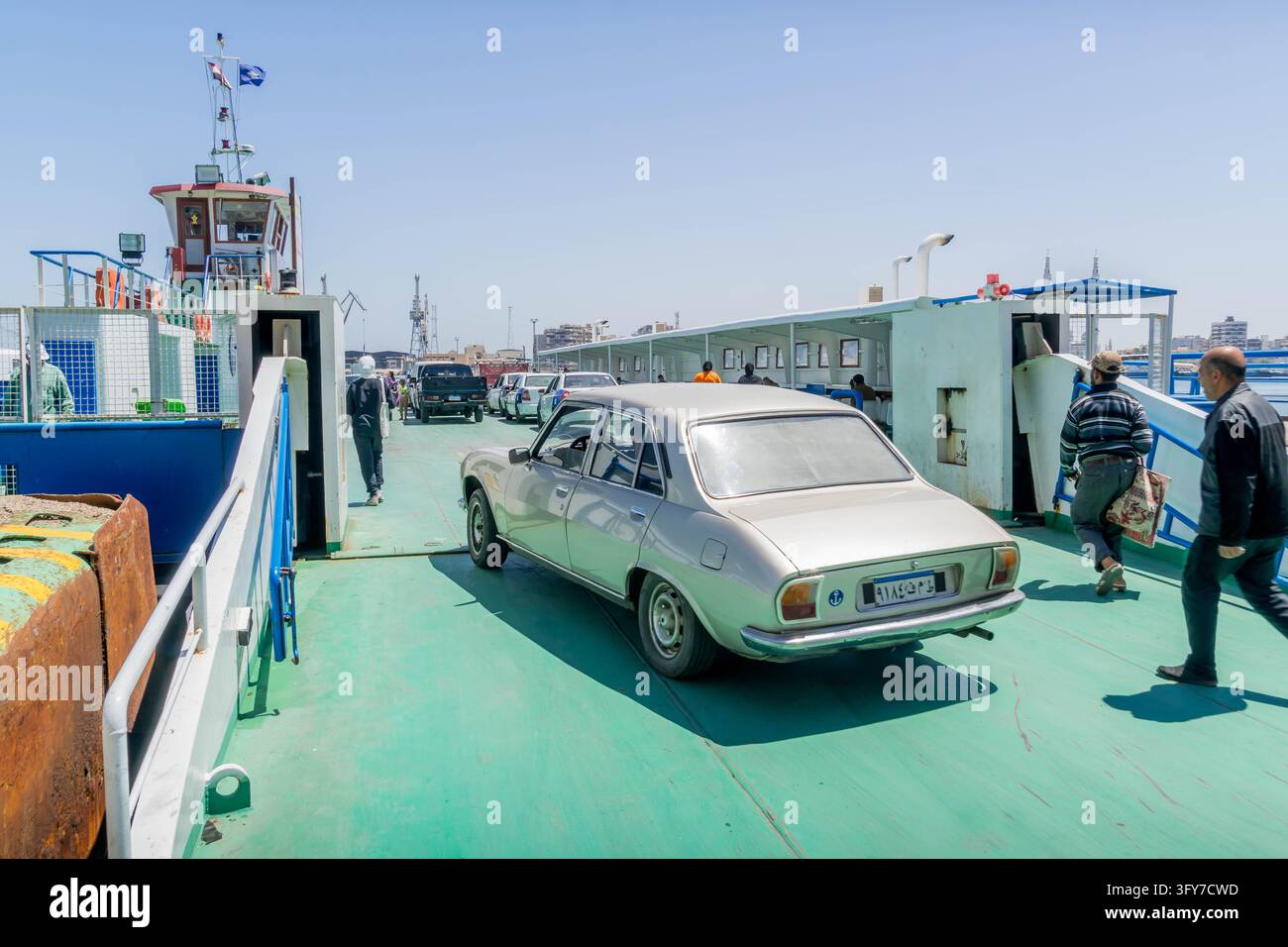 Véhicules et passagers embarquent sur un bac automobile reliant Port-Saïd et Port-Fuad à travers le couloir de transit du canal de Suez en Égypte. Banque D'Images