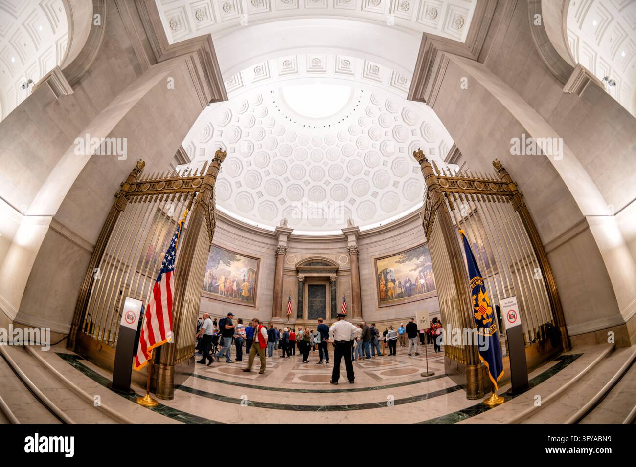 Entrée de la rotonde des Archives nationales avec des drapeaux à Washington DC | WASHINGTON — Le drapeau des Archives nationales se dresse à côté des grilles d’entrée en bronze de la rotonde du bâtiment des Archives nationales à Washington, D.C. Au-delà des portes, une coupole à caissons abrite les Charte des Libertés et les fresques de l’époque de la fondation de Barry Faulkner. John Russell Pope a dessiné la cassetture octogonale de la coupole d’après le Panthéon romain. Banque D'Images