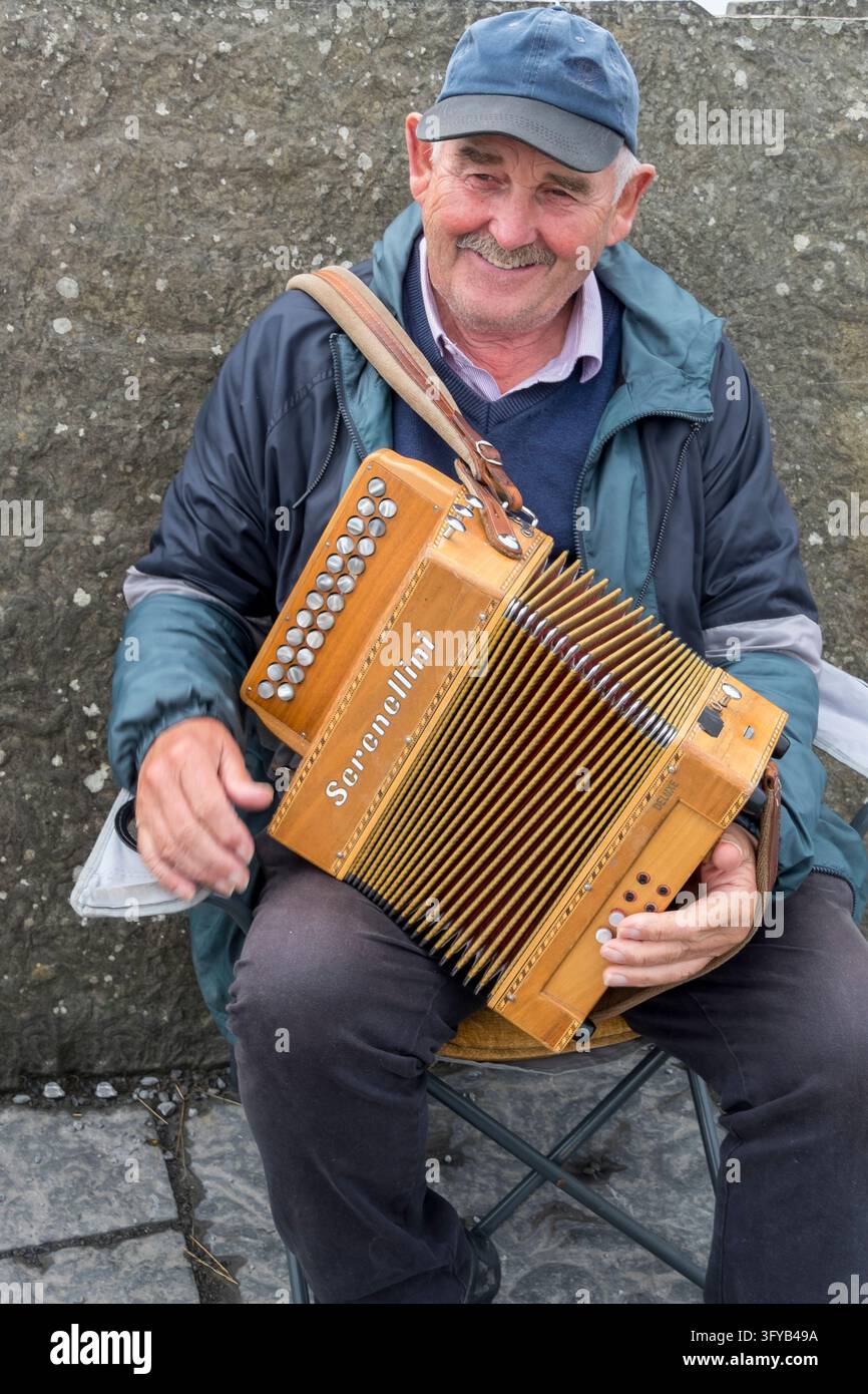 Homme et accordéon aux falaises de Moher Banque D'Images