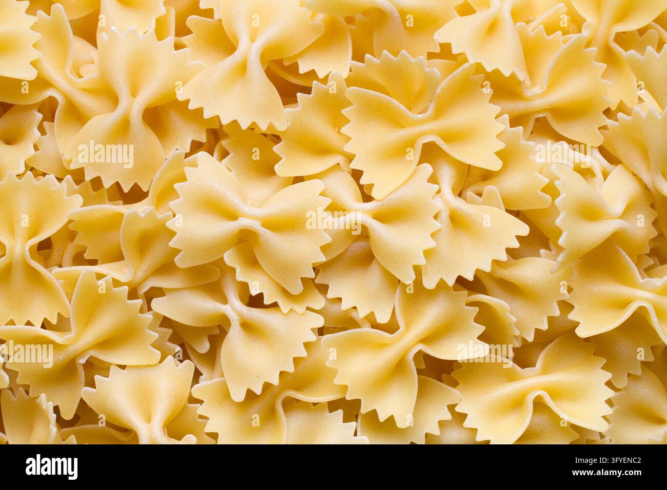Pâtes crues en forme d'arcs, texture. Beaucoup de pâtes en forme d'arcs Banque D'Images