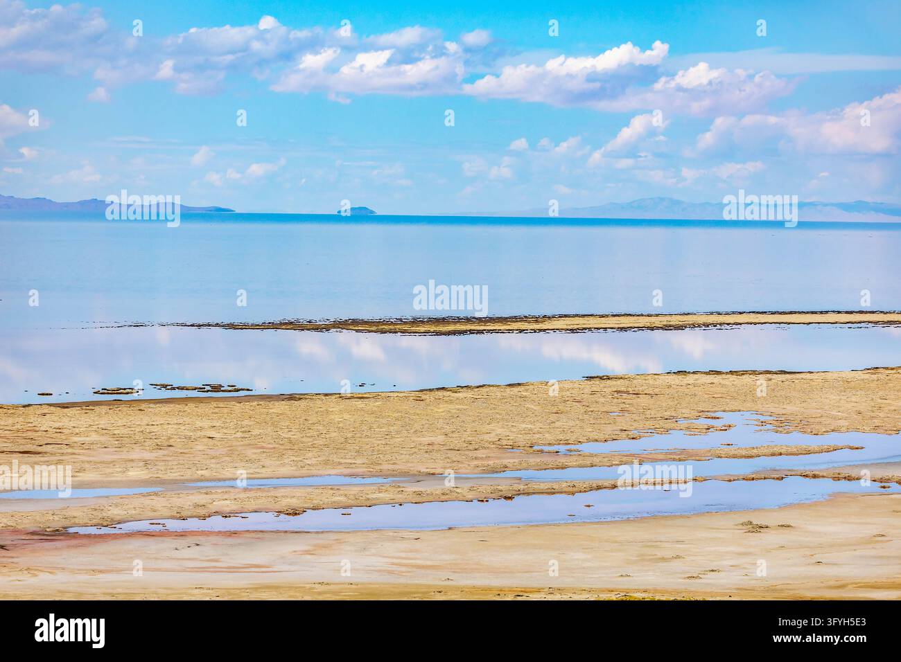 Les eaux calmes du Grand Lac Salé reflètent les chaînes de montagnes lointaines le long de la rive du parc d'État d'Antelope Island dans l'Utah Banque D'Images