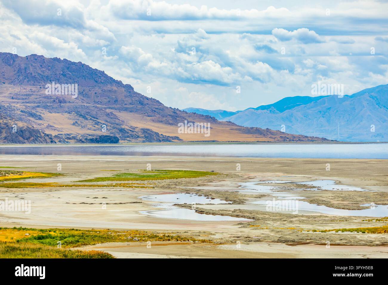 Les eaux calmes du Grand Lac Salé reflètent les chaînes de montagnes lointaines le long de la rive du parc d'État d'Antelope Island dans l'Utah Banque D'Images