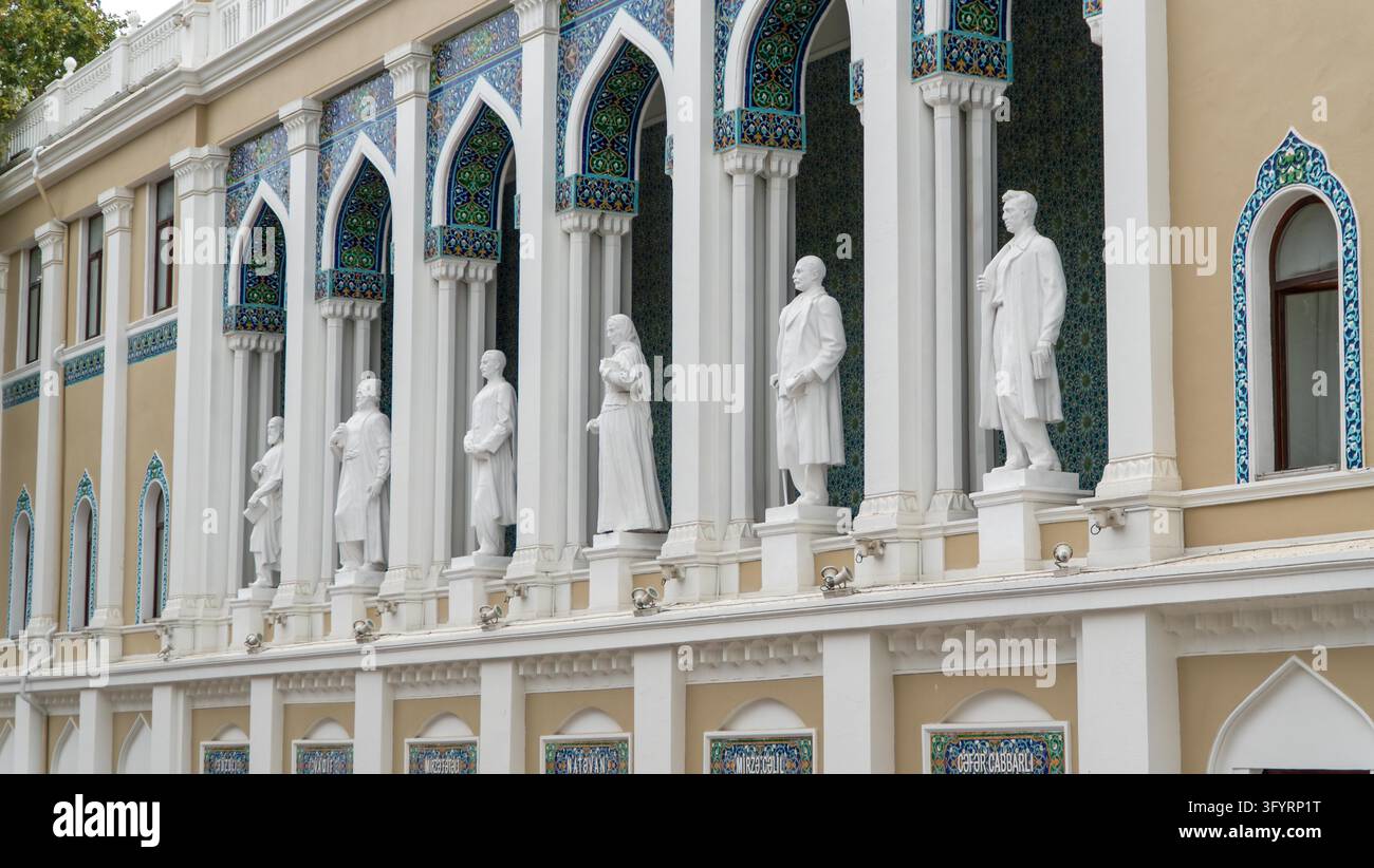 Baku, Azerbaïdjan - 14 octobre 2024 : Statues blanches de poètes classiques dans des niches cintrées carrelées sur la façade du musée Nizami de littérature azérie Banque D'Images