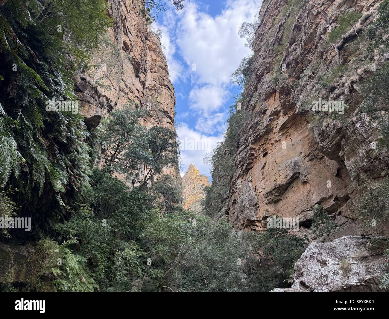 Une bande de ciel bleu apparaît entre des falaises de grès érodées imposantes dans le parc national d'Isalo, à Madagascar. - Image de stock capturée avec un smartphone