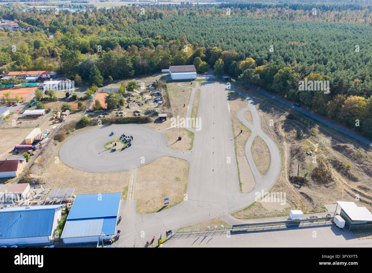 Vue aérienne du Centre de sécurité des motos avec une piste d'entraînement, des chemins en asphalte, une zone circulaire avec des motos et une forêt à Bad Schönborn-Kronau Banque D'Images