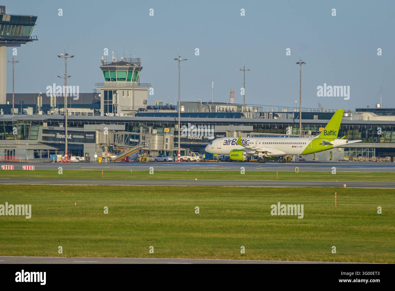 Riga, Lettonie - 27 octobre 2026 : avion de ligne AirBaltic sur le tarmac de l'aéroport international de Riga, Lettonie, avec le terminal et le contrôle aérien Banque D'Images