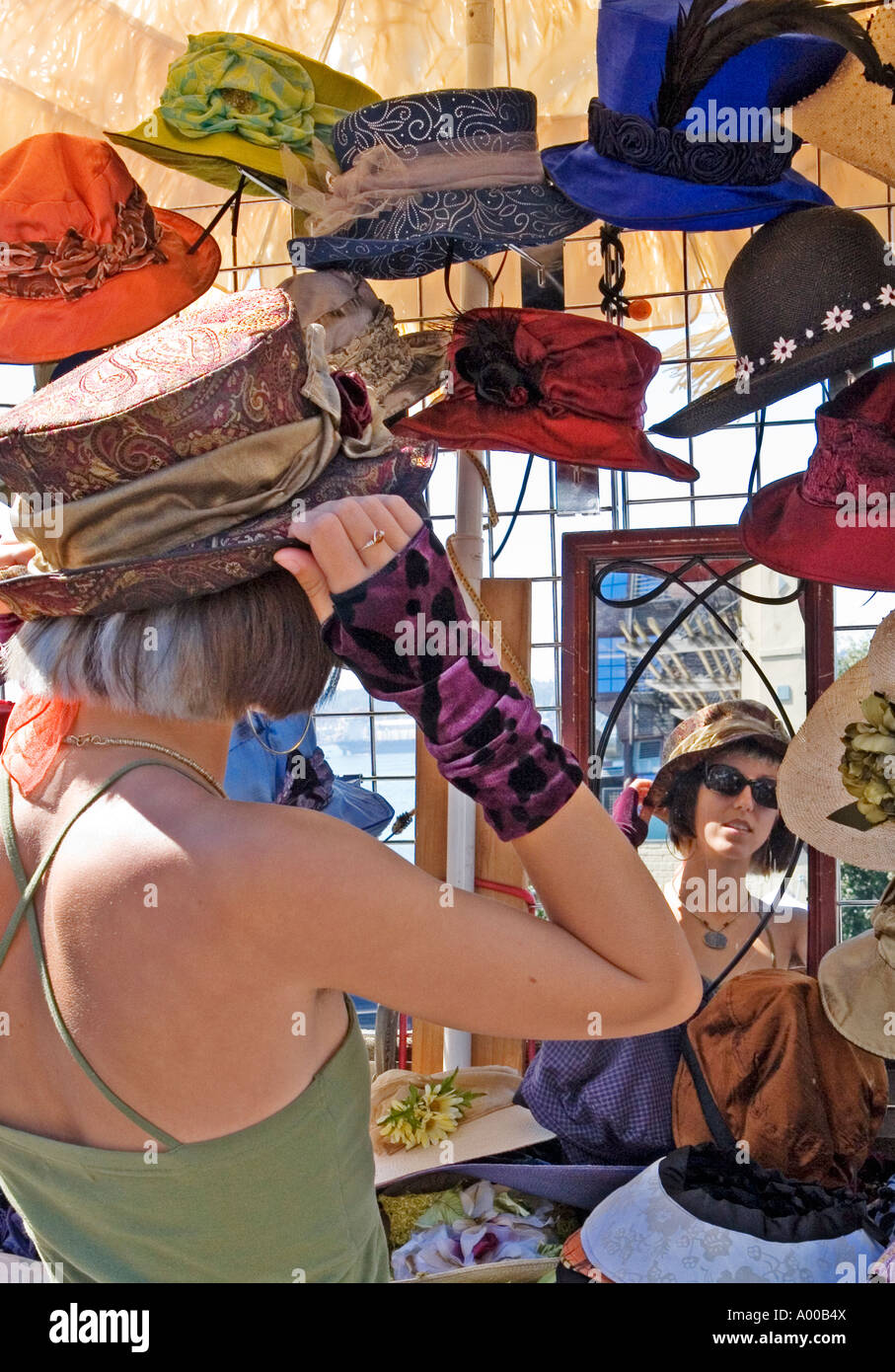 Image d'une jeune fille essayant sur un chapeau tout en regardant dans un  miroir à l'ancienne entourée d'autres chapeaux sur l'affichage Photo Stock  - Alamy