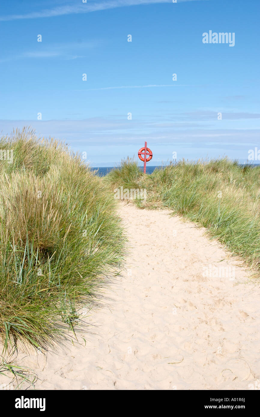Chemin de plage avec des dunes de sable grâce à la vie rouge anneau attaché à la ceinture de croix en bois rouge Banque D'Images