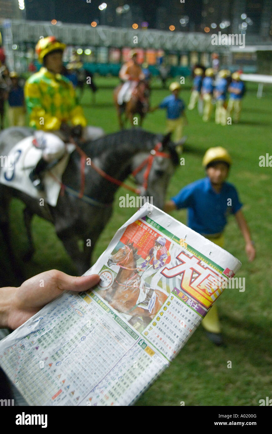 Contrôle de l'homme sous forme de cheval dans du papier journal à Happy Valley racecourse Hong Kong Banque D'Images