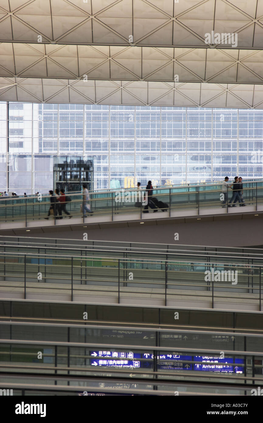 Les passagers à marcher le long des rampes d'accès à l'Aéroport International de Hong Kong Banque D'Images