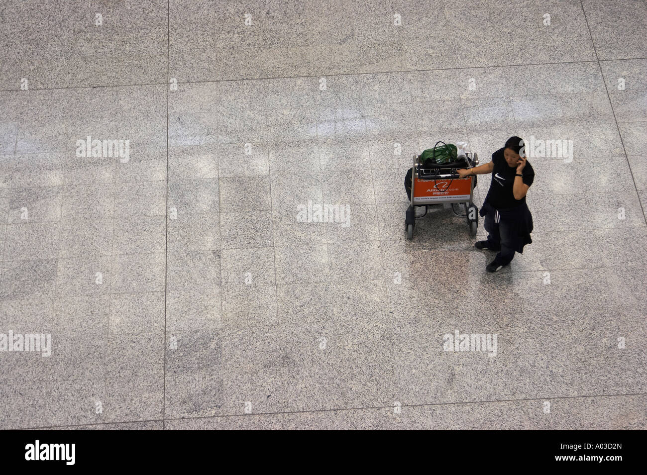 Femme parlant au téléphone cellulaire à l'Aéroport International de Hong Kong Banque D'Images