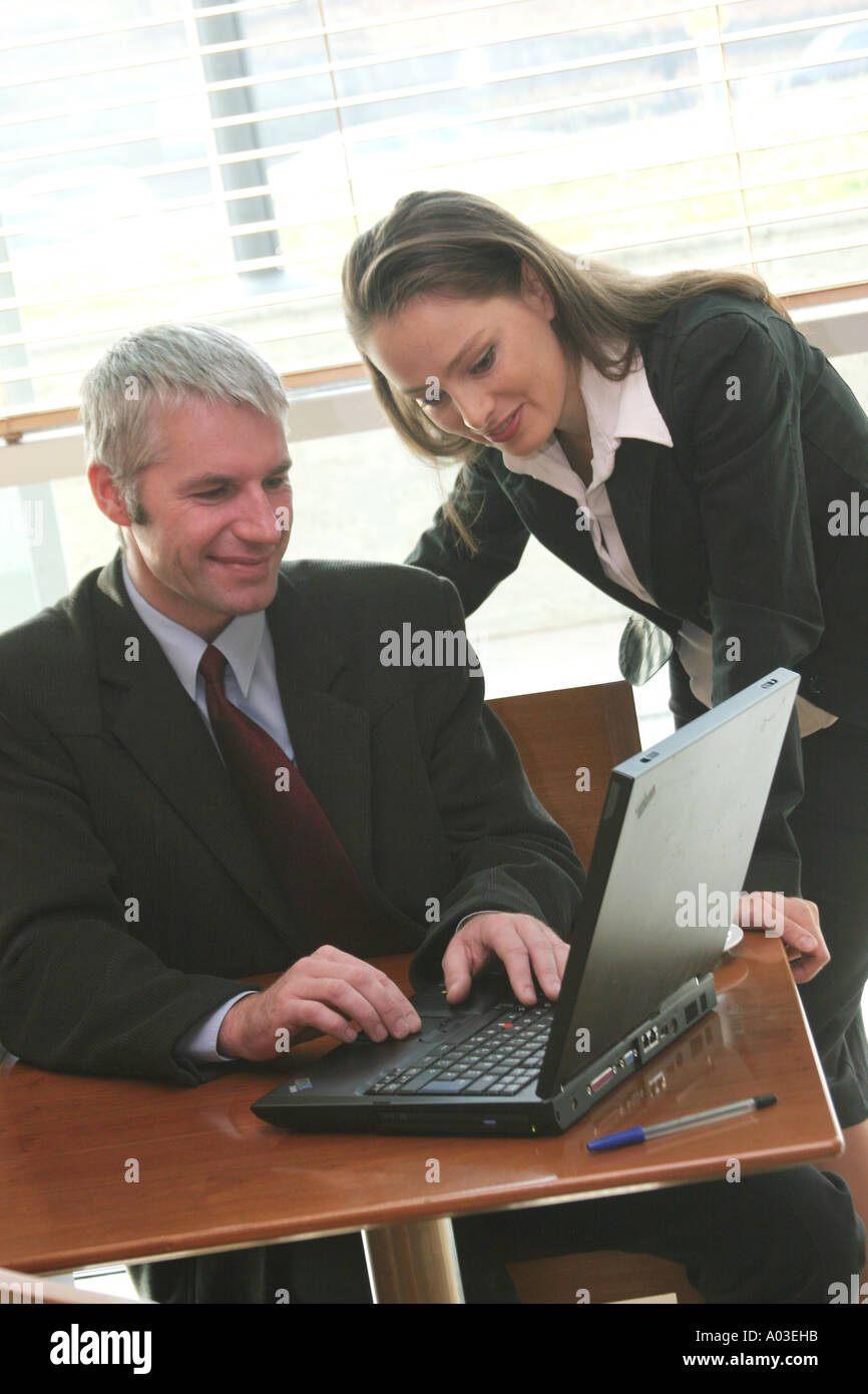 Businessman and businesswoman looking at ordinateur portable Banque D'Images