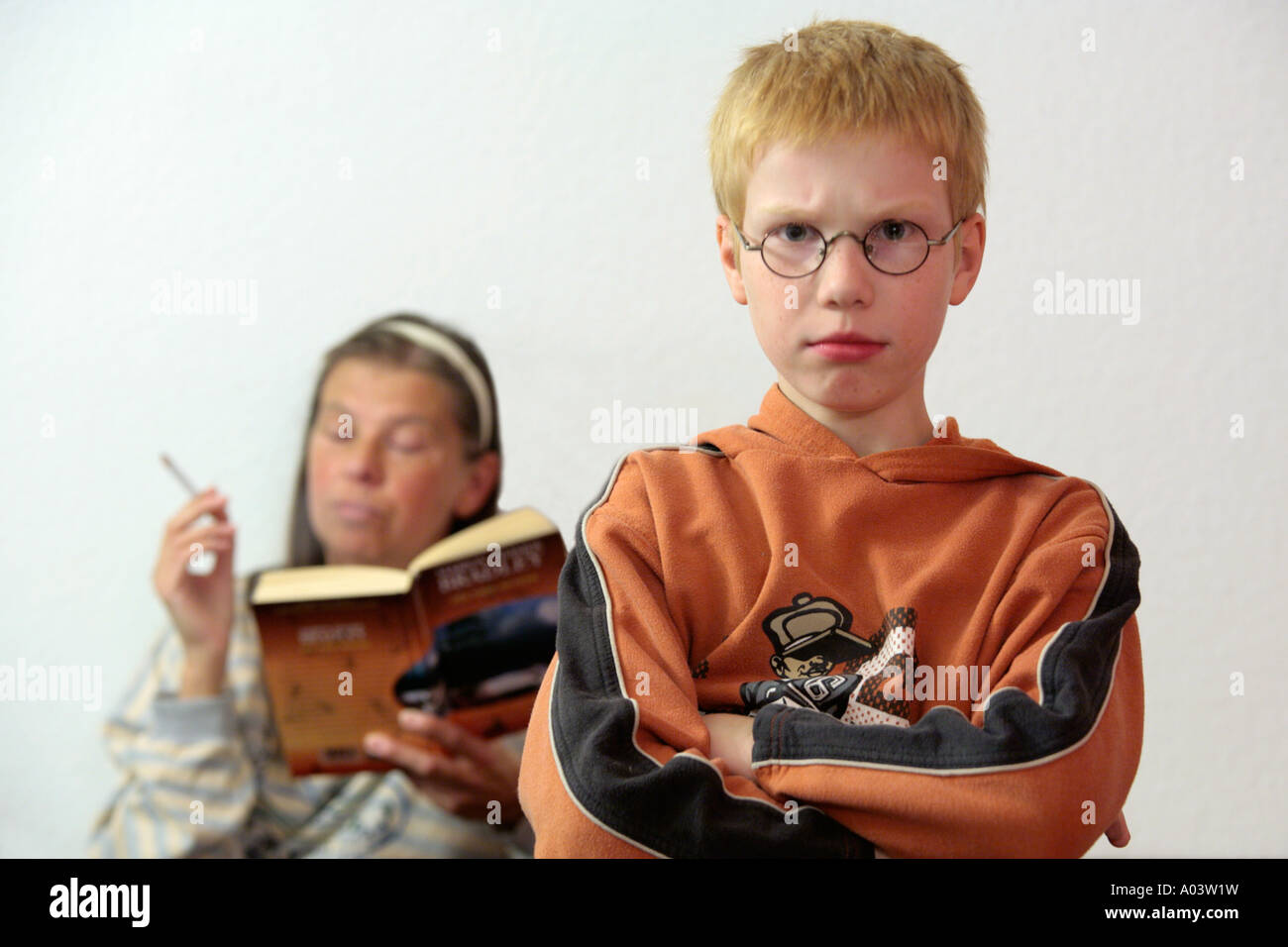 Mère de fumer une cigarette pendant que son soleil est bouder Photo Stock -  Alamy