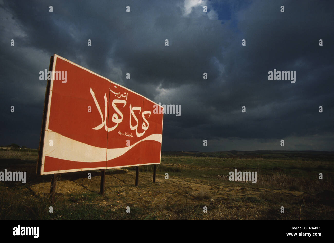 Plaque publicitaire coca cola dans le désert rouge ciel noir signes arabe Banque D'Images