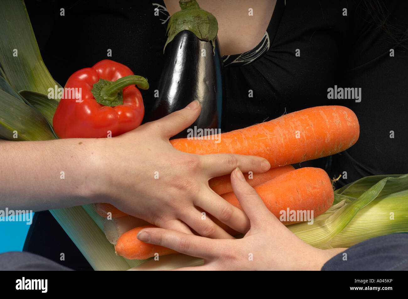 Jeune femme tenant des légumes frais à sa poitrine comme un bouquet de fleurs Banque D'Images