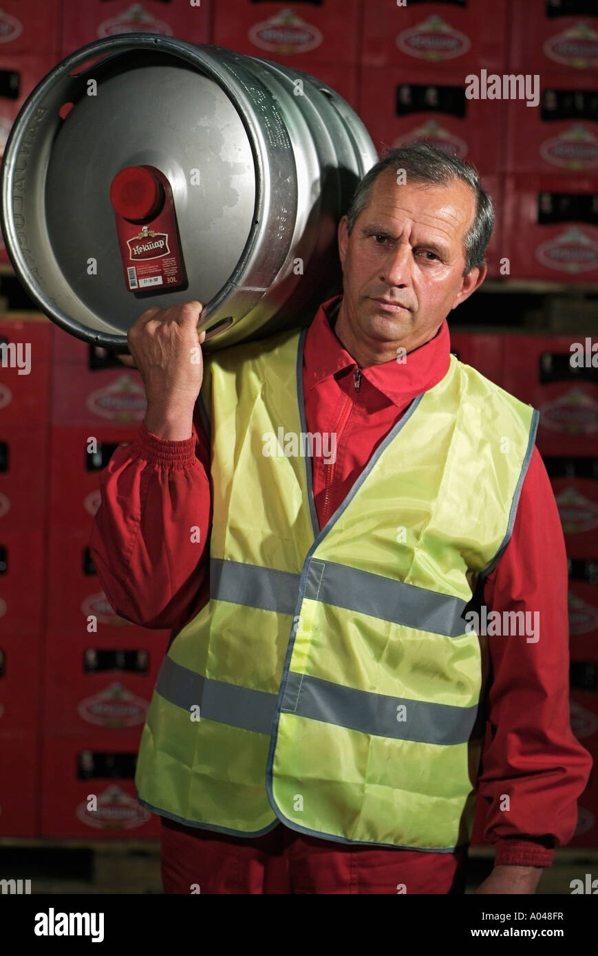 Homme portant un baril de bière sur son épaule dans un entrepôt de la brasserie Banque D'Images