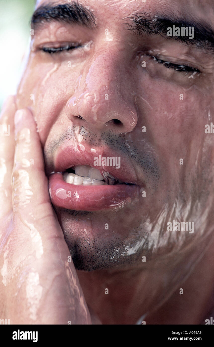 Portrait d'un jeune homme avec de l'eau couler sur son visage Banque D'Images