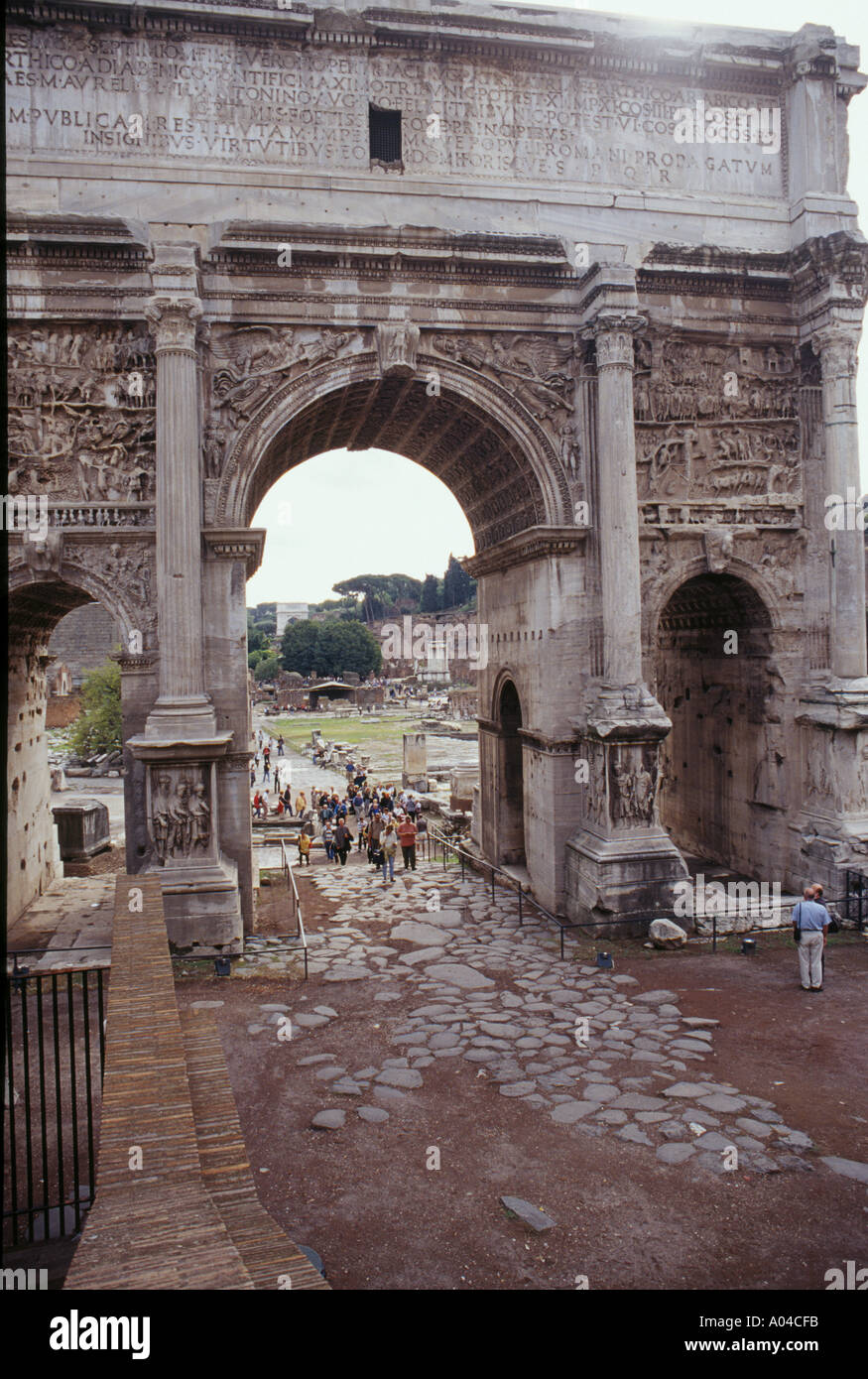 Les touristes se promener sous l'Arc de Septime Sévère à l'entrée du Forum Romain Banque D'Images