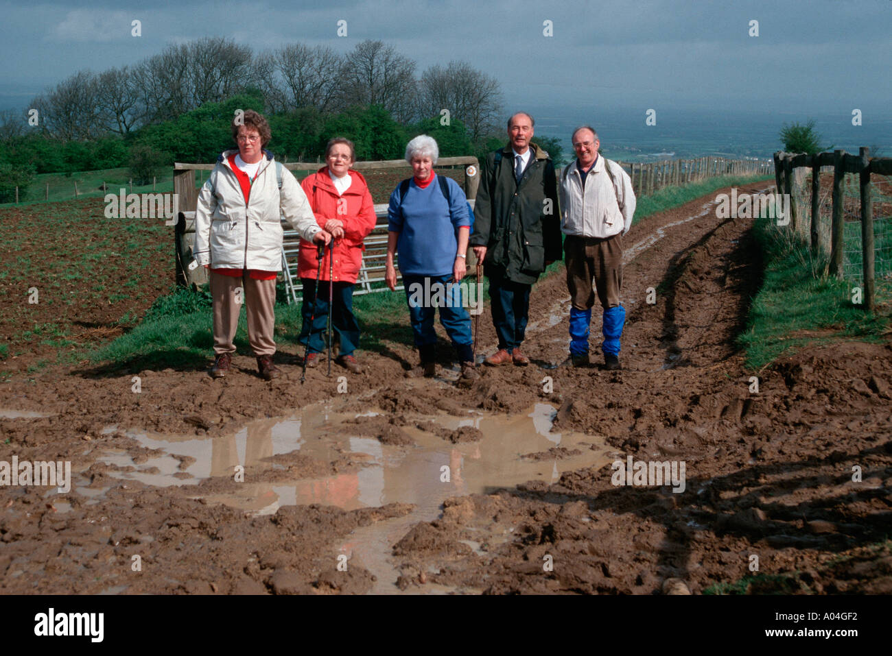 Les personnes âgées marche sur piste boueuse Cotswolds UK Banque D'Images