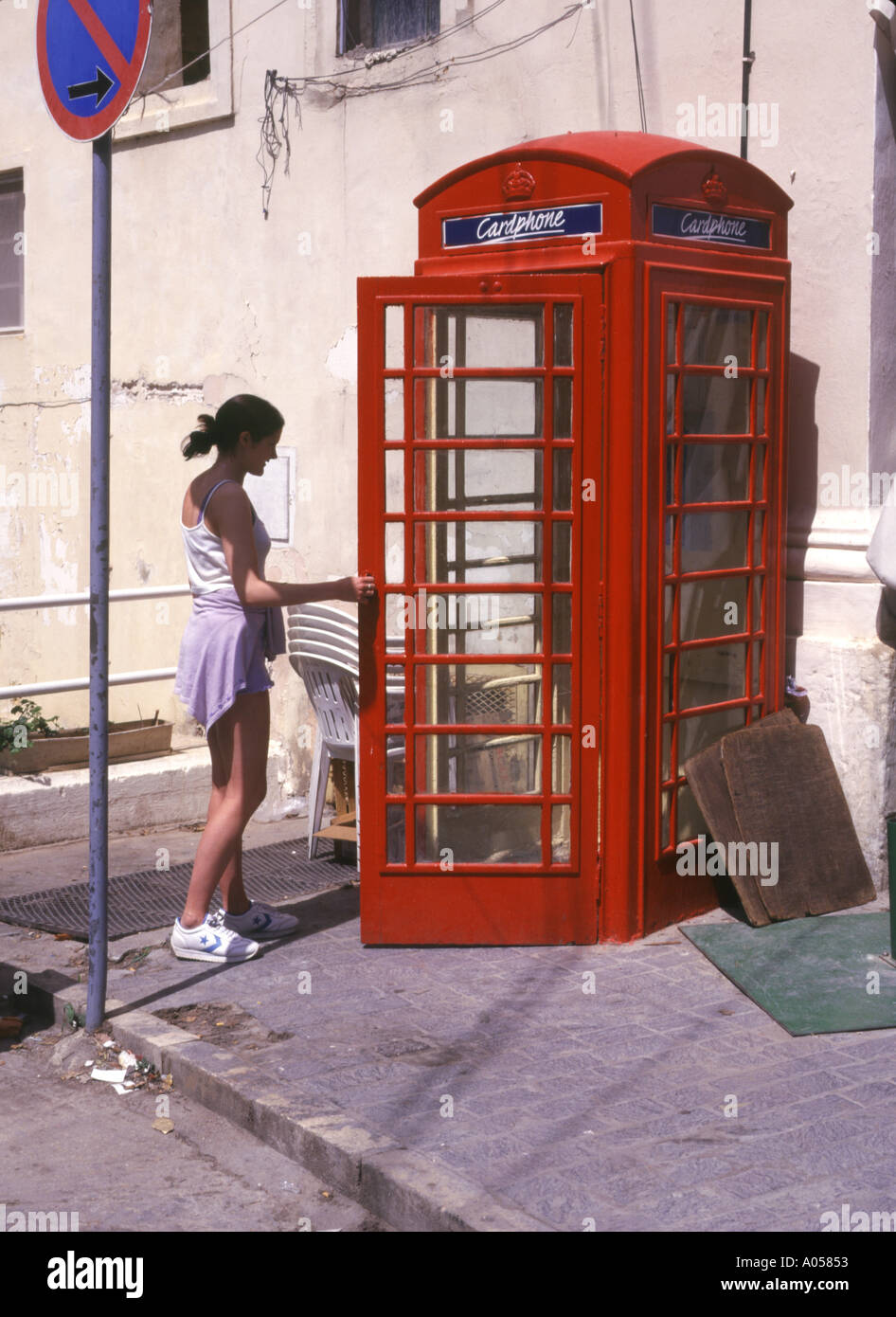 dh VICTORIA GOZO Girl touriste entrant dans le pilier de style britannique maltais rouge téléphone boîte malte Banque D'Images