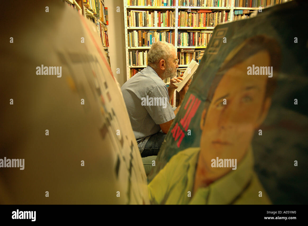 Un homme âgé lit un livre dans une librairie d'occasion à Jérusalem-Ouest israël Banque D'Images