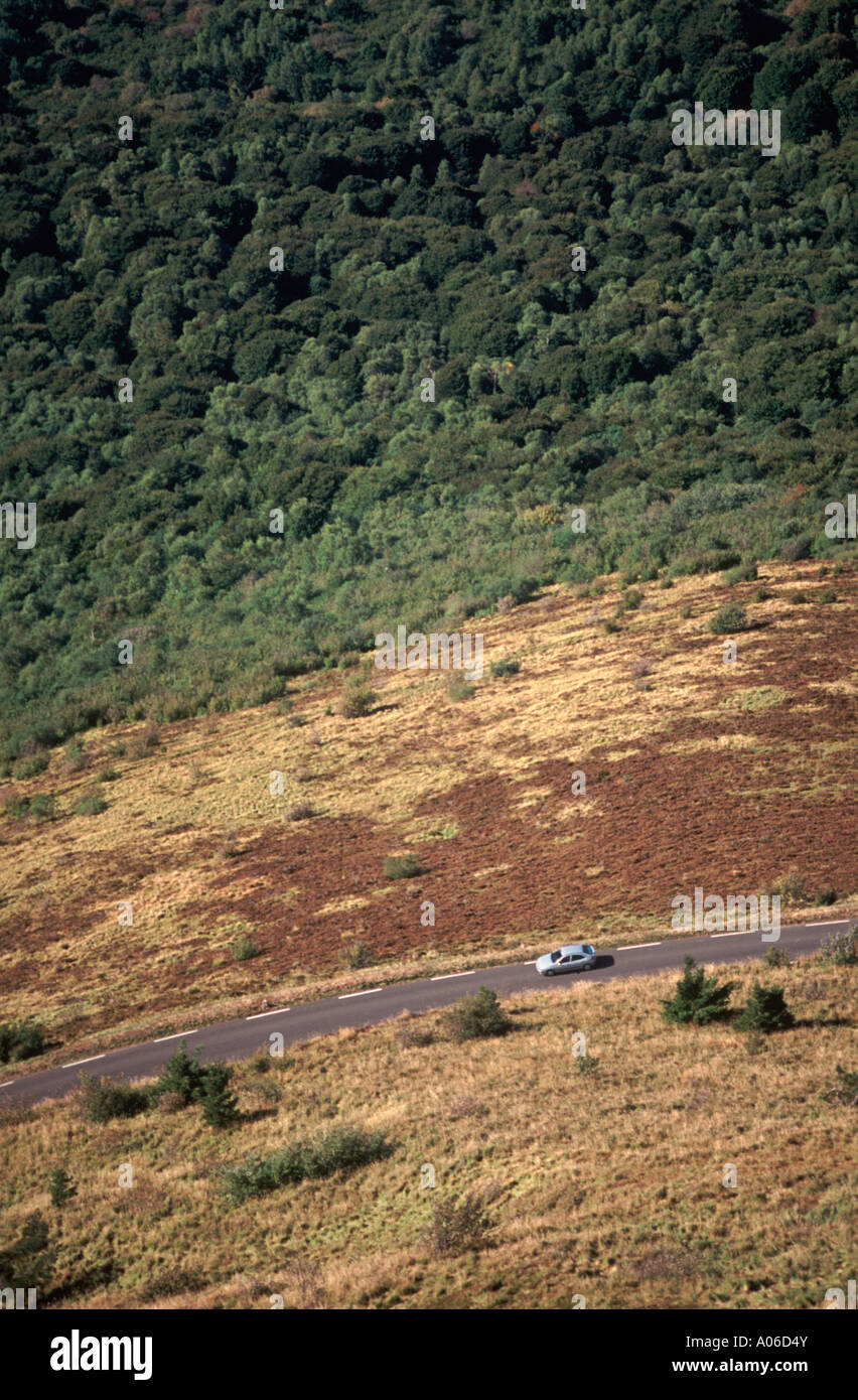 Voiture roulant sur route ouverte par paysage volcanique ci-dessous Puy de Dôme (près de Clermont-Ferrand), France Banque D'Images