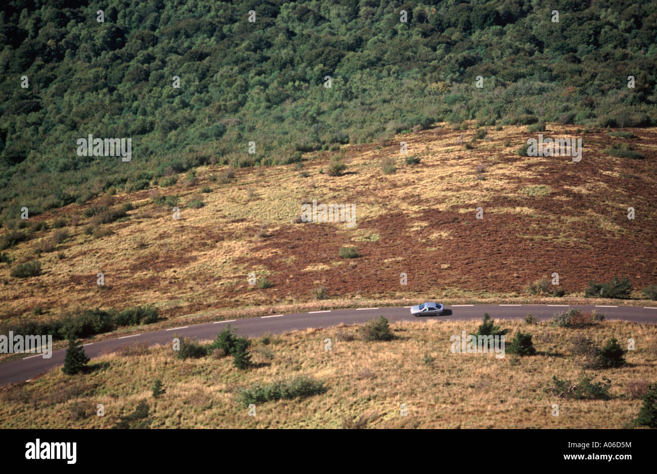 Voiture roulant sur route ouverte par paysage volcanique ci-dessous Puy de Dôme (près de Clermont-Ferrand), France Banque D'Images