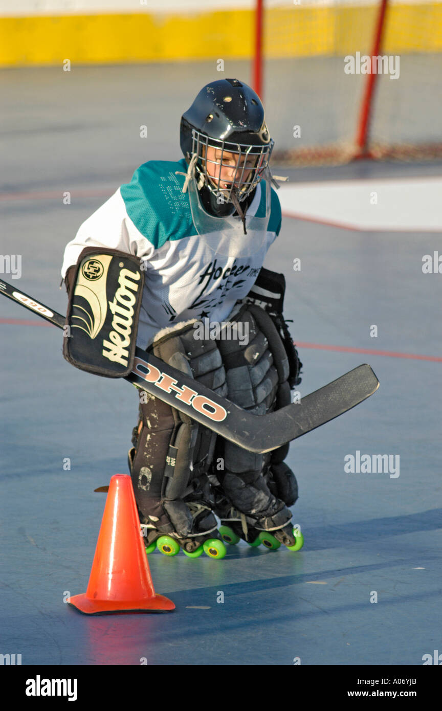 10 garçon de dix ans pendant la pratique avec le roller hockey équipe avec équipement de sécurité complet sur patins dans le jeu local en été et en autocar Banque D'Images