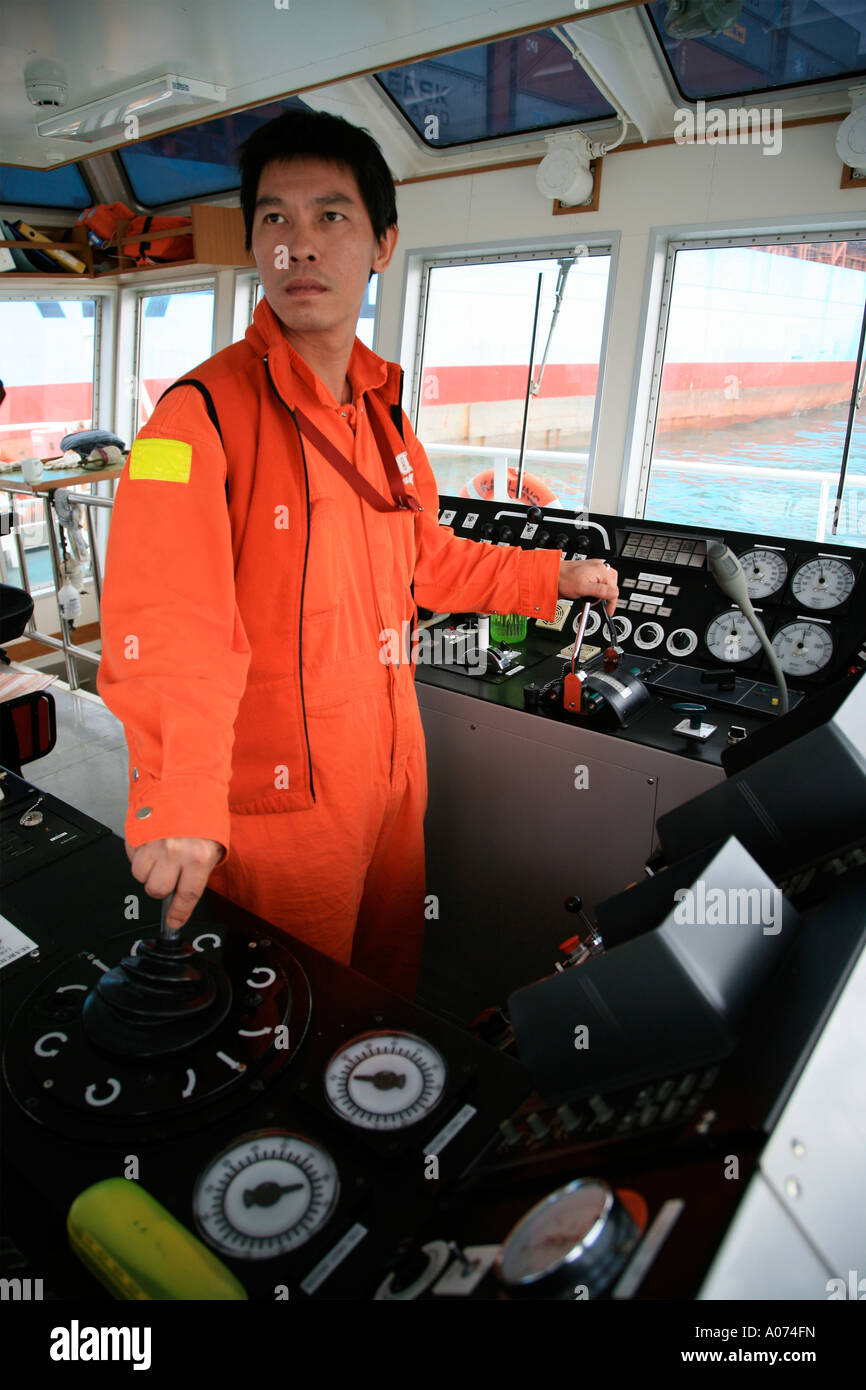 Le capitaine de remorqueur de graphique à l'aide de commandes tout en manoevering par porte-conteneurs à Kwai Chung container port hong kong Banque D'Images