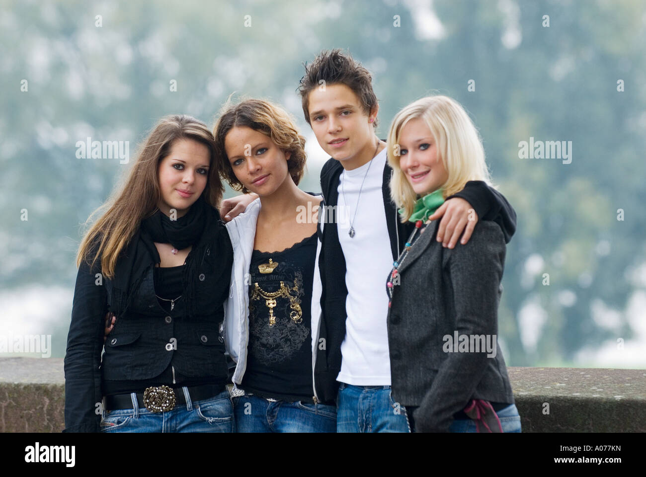 Groupe de quatre adolescents de race blanche, un garçon et trois filles sourire dans Appareil photo Banque D'Images