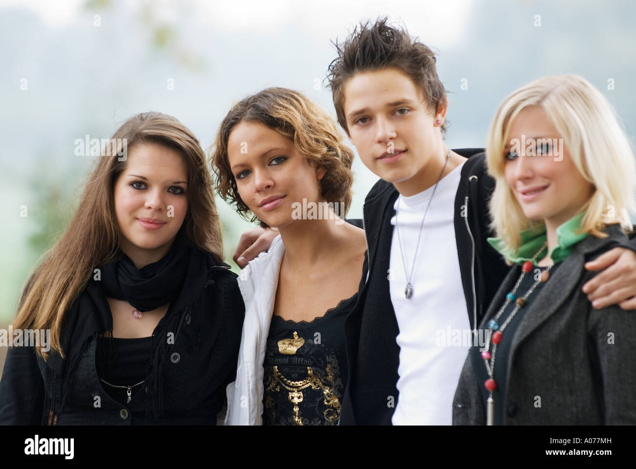 Groupe de quatre adolescents de race blanche, un garçon et trois filles sourire dans Appareil photo Banque D'Images