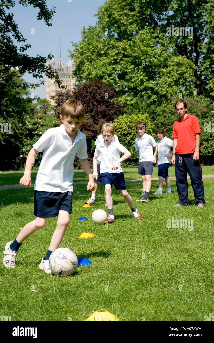 Les garçons de l'école leur enseigne des compétences de football en Angleterre Banque D'Images