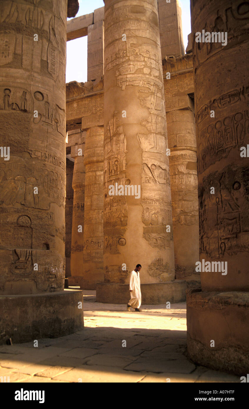 Un homme marche à travers la salle hypostyle du Temple de Karnak (Egypte) Banque D'Images