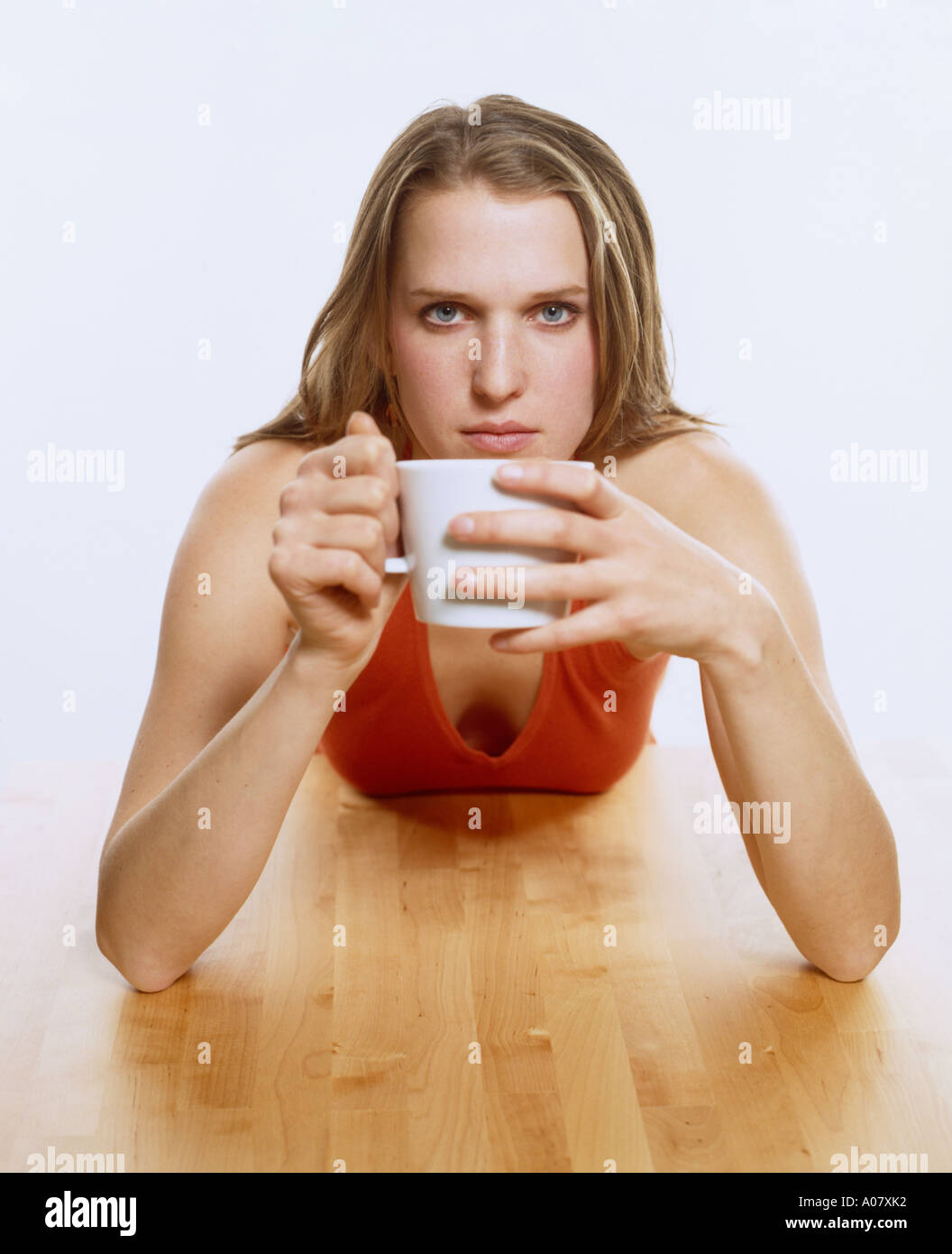 Young woman at table with coffee cup Banque D'Images