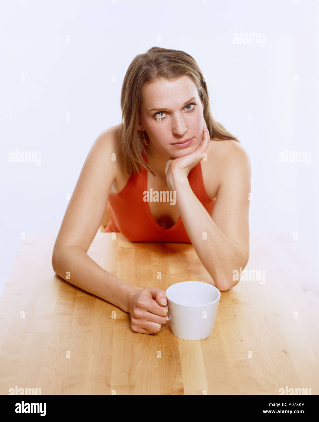 Young woman at table with coffee cup Banque D'Images