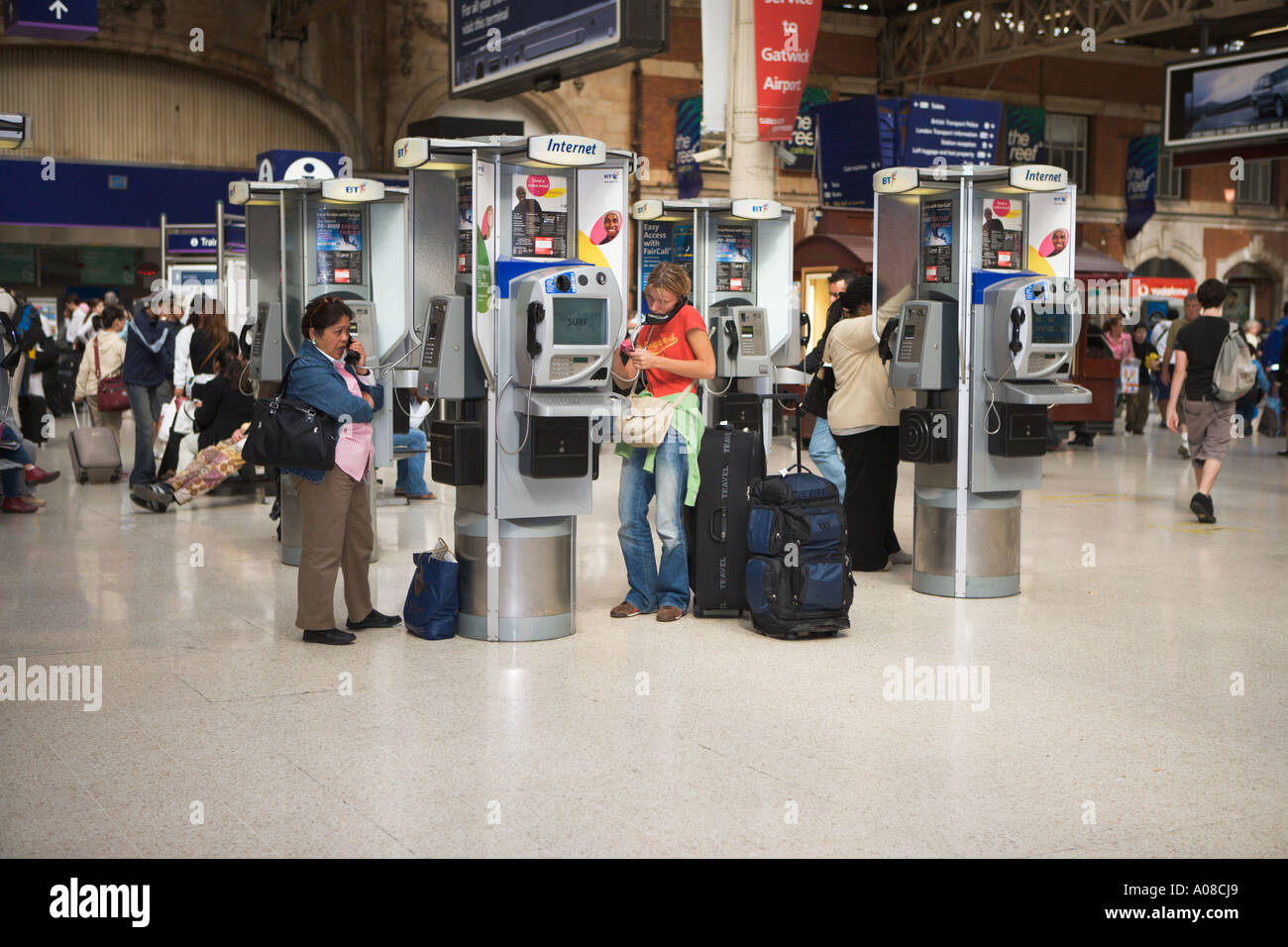 Les gens à l'aide d'un téléphone public à la gare de Victoria, Londres. Banque D'Images