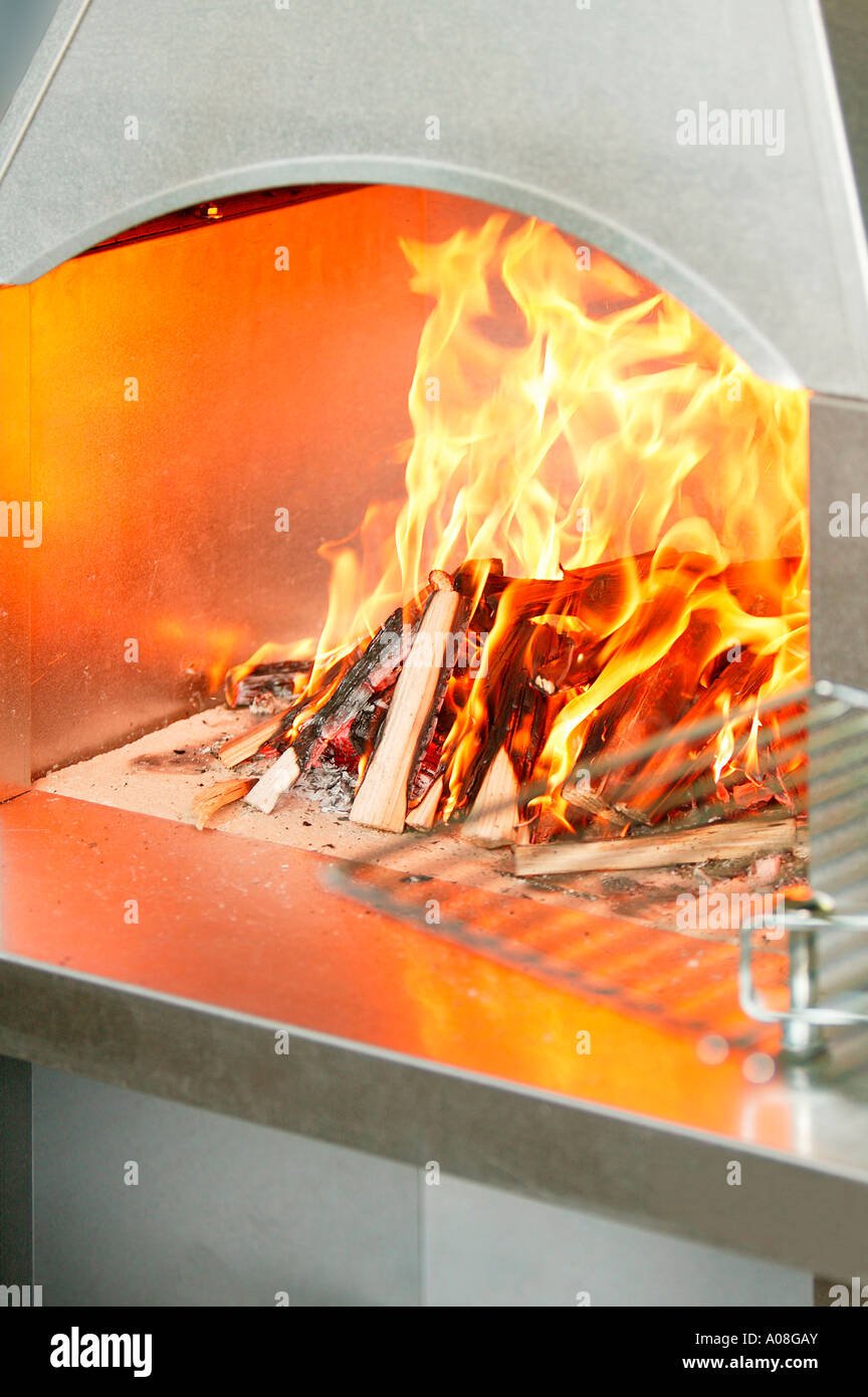 Brennende Holzscheite Gartengrille in, la combustion de bois dans un barbecue Banque D'Images