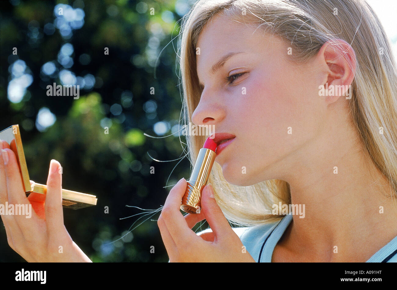 Young woman applying lipstick Banque D'Images