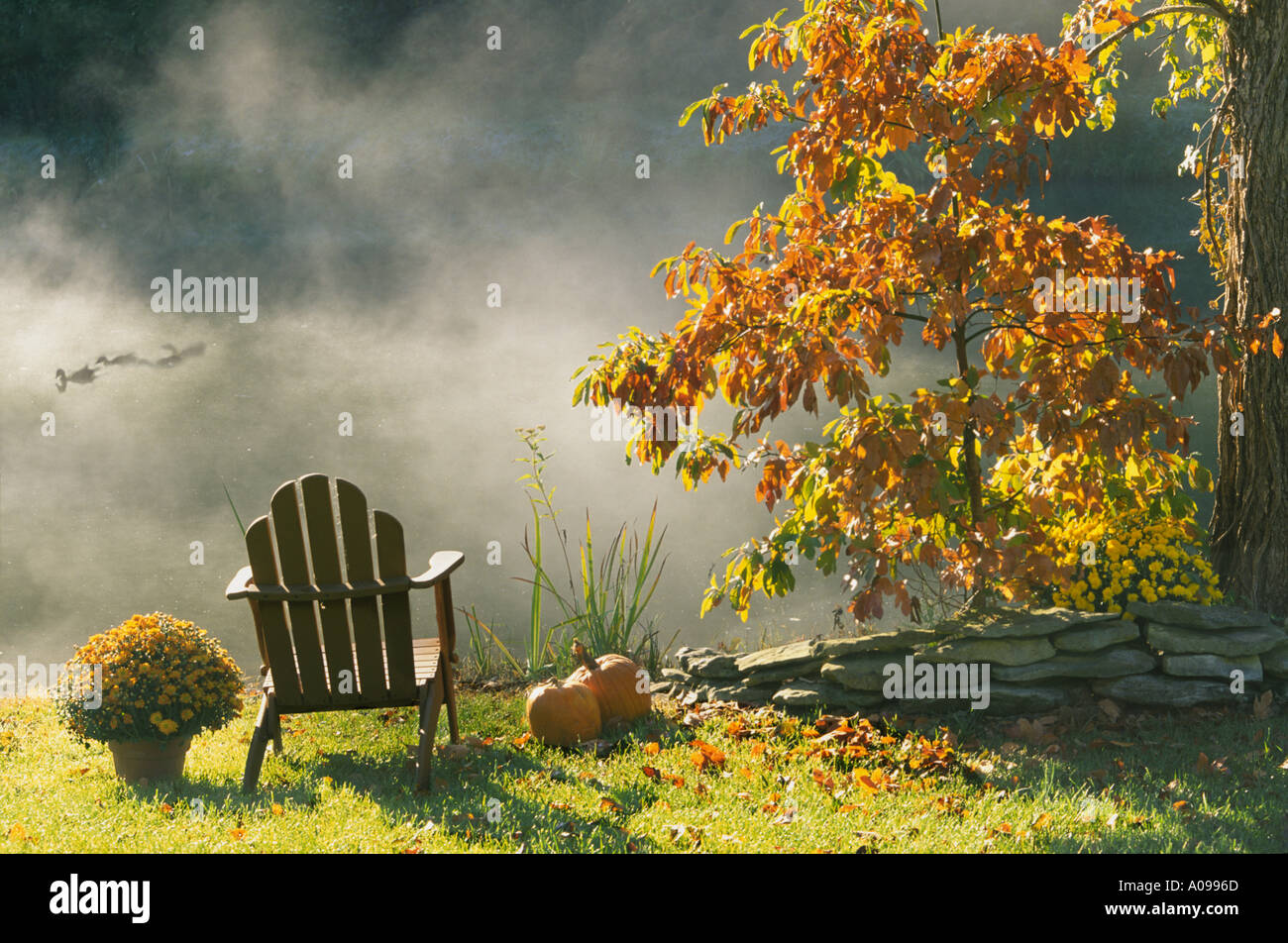 Lumière dorée : une chaise Adirondack en fin d'automne après-midi au bord du lac avec mist rising et couleur orange - seul avec les canards, Midwest USA Banque D'Images