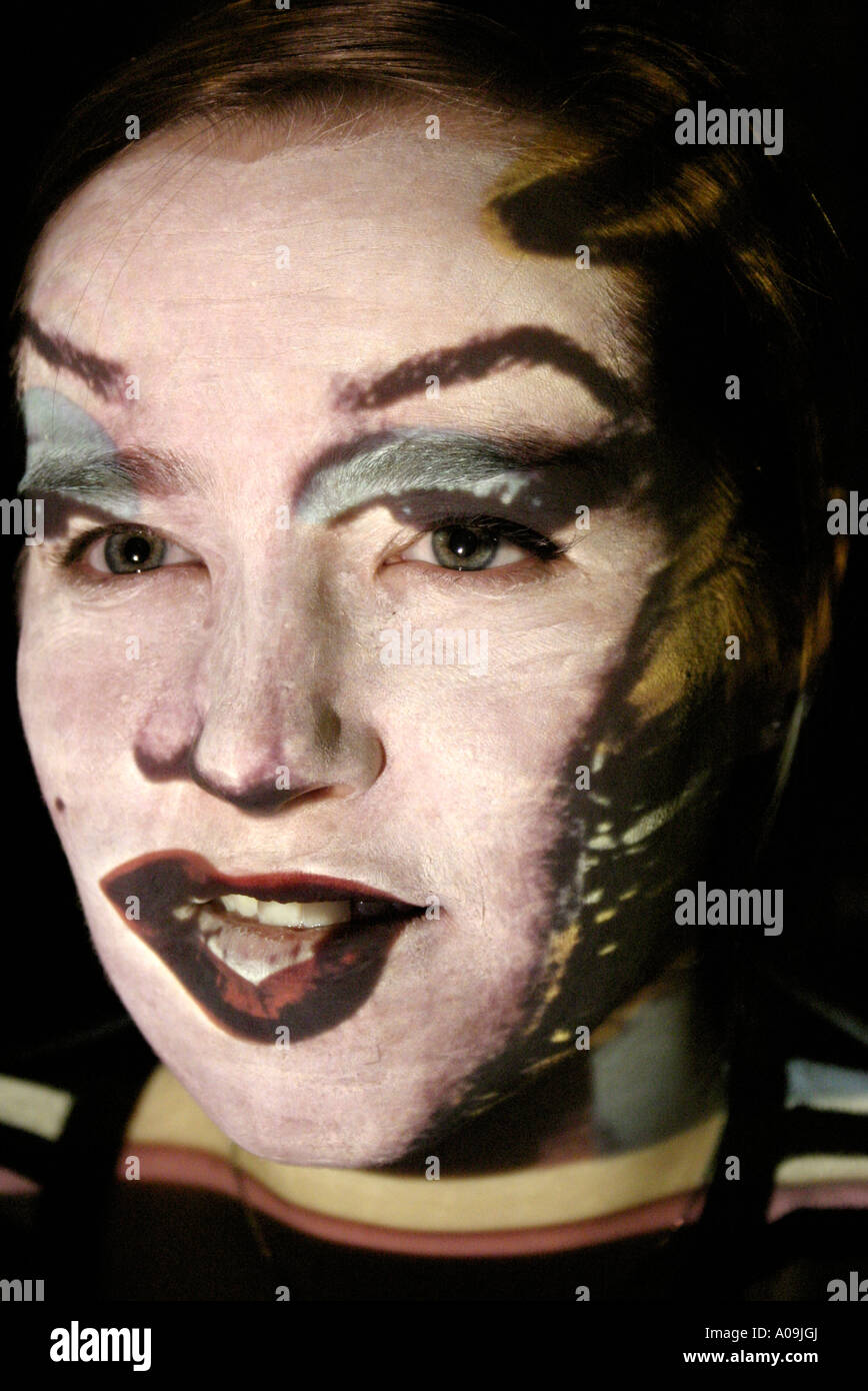 Andy Warol's Marilyn Monroe projetée sur Young Woman's Face Banque D'Images
