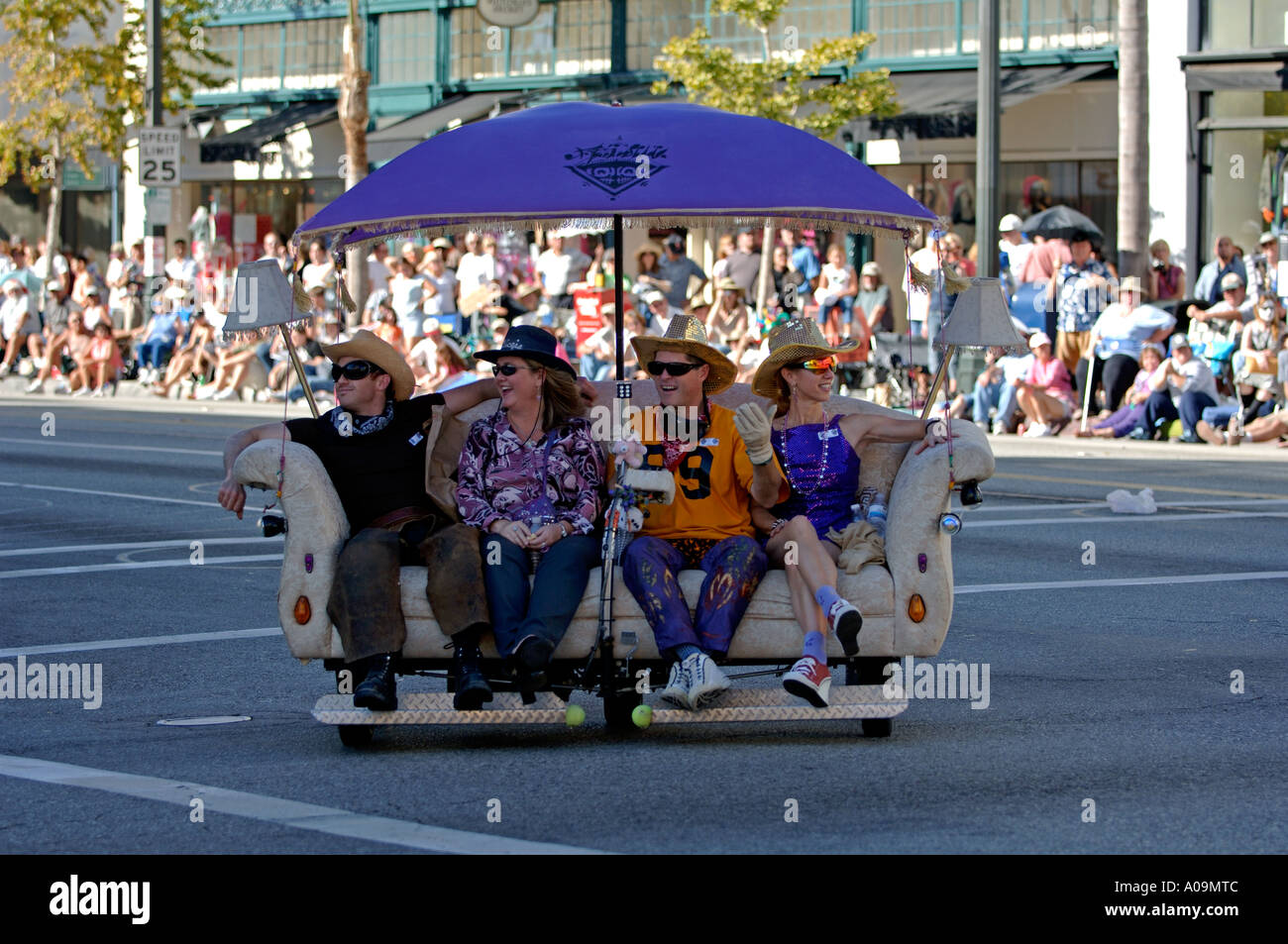 Quatre personnes assises sur un canapé motorisé avec roues à la Pasadena Doo Dah Parade Banque D'Images