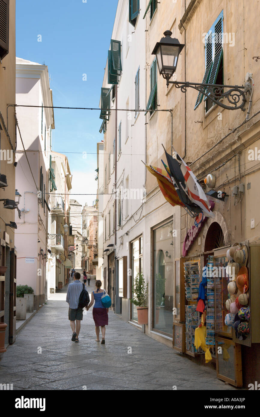 Couple en train de marcher dans une rue de la vieille ville, Alghero, Sardaigne, Italie Banque D'Images