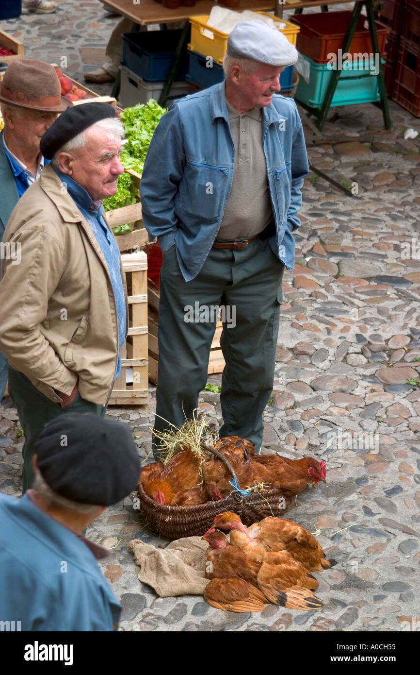 De vieux hommes vendre les poulets à un marché de village Banque D'Images