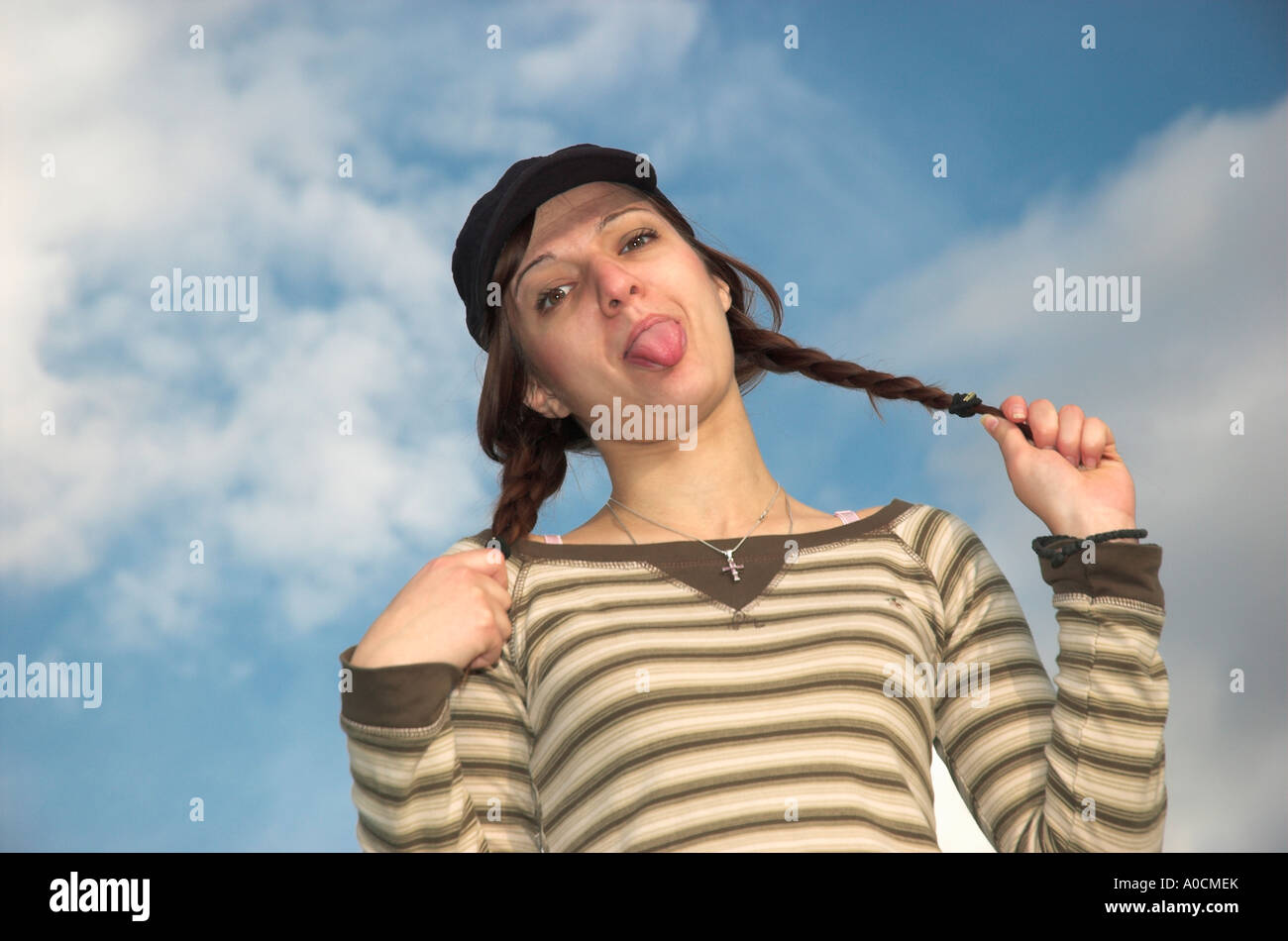 Young Woman Pulling Pigtails Sticking Tongue Out Banque D'Images