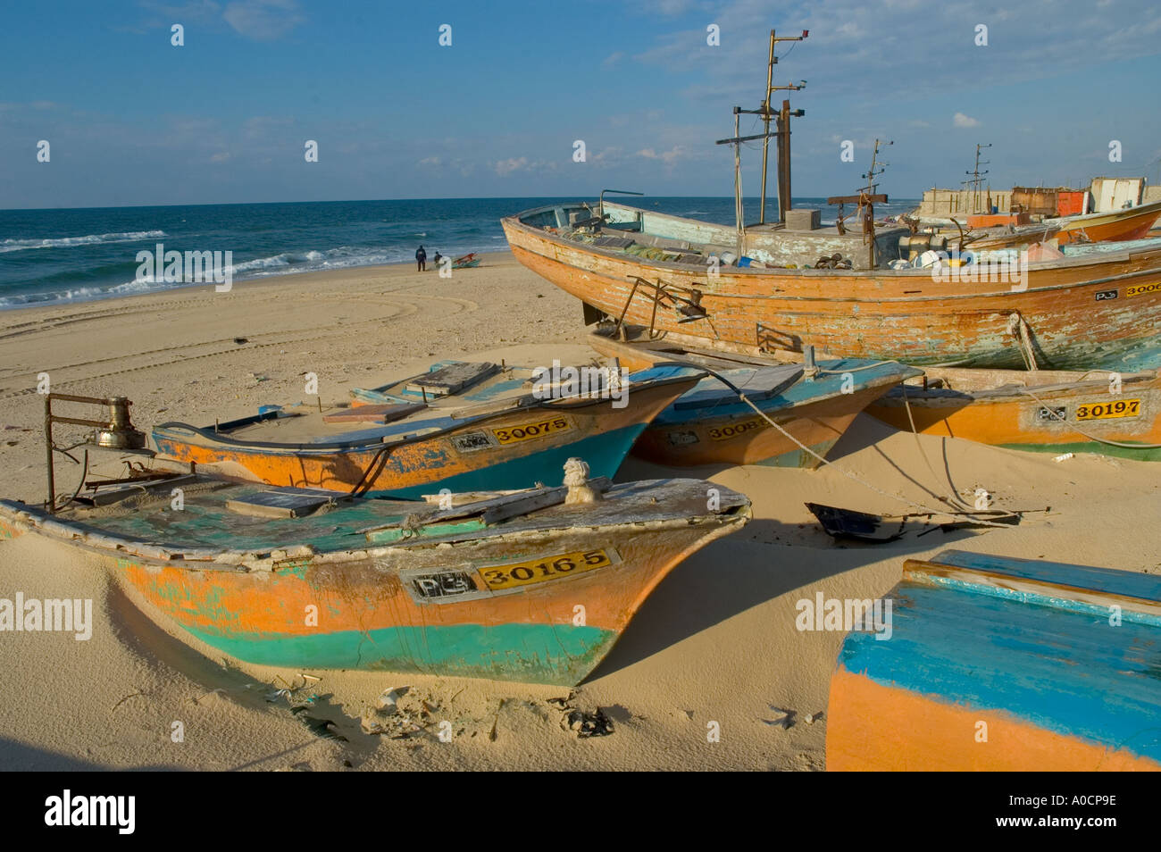 La bande de Gaza Al Mawassi enclave de Gush Katif dry bateaux de pêche sur la plage la moitié enterré en mer en sandwith bkgd Banque D'Images