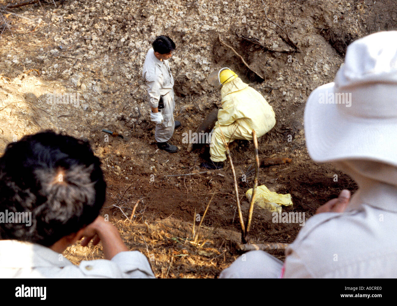 Les techniciens UXO Lao sur le fil d'une charge de bombes au phosphore de détonation dans une carrière près de la Plaine des Jarres Phonsavan Laos du nord Banque D'Images