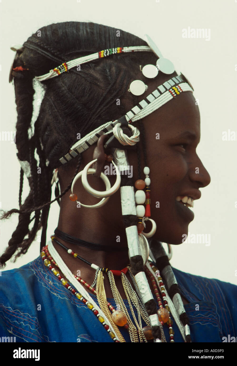 Dans un style de cheveux silver crest Maria Theresa dollars et perles de verre ornent une femme Peul du Burkina Faso Banque D'Images