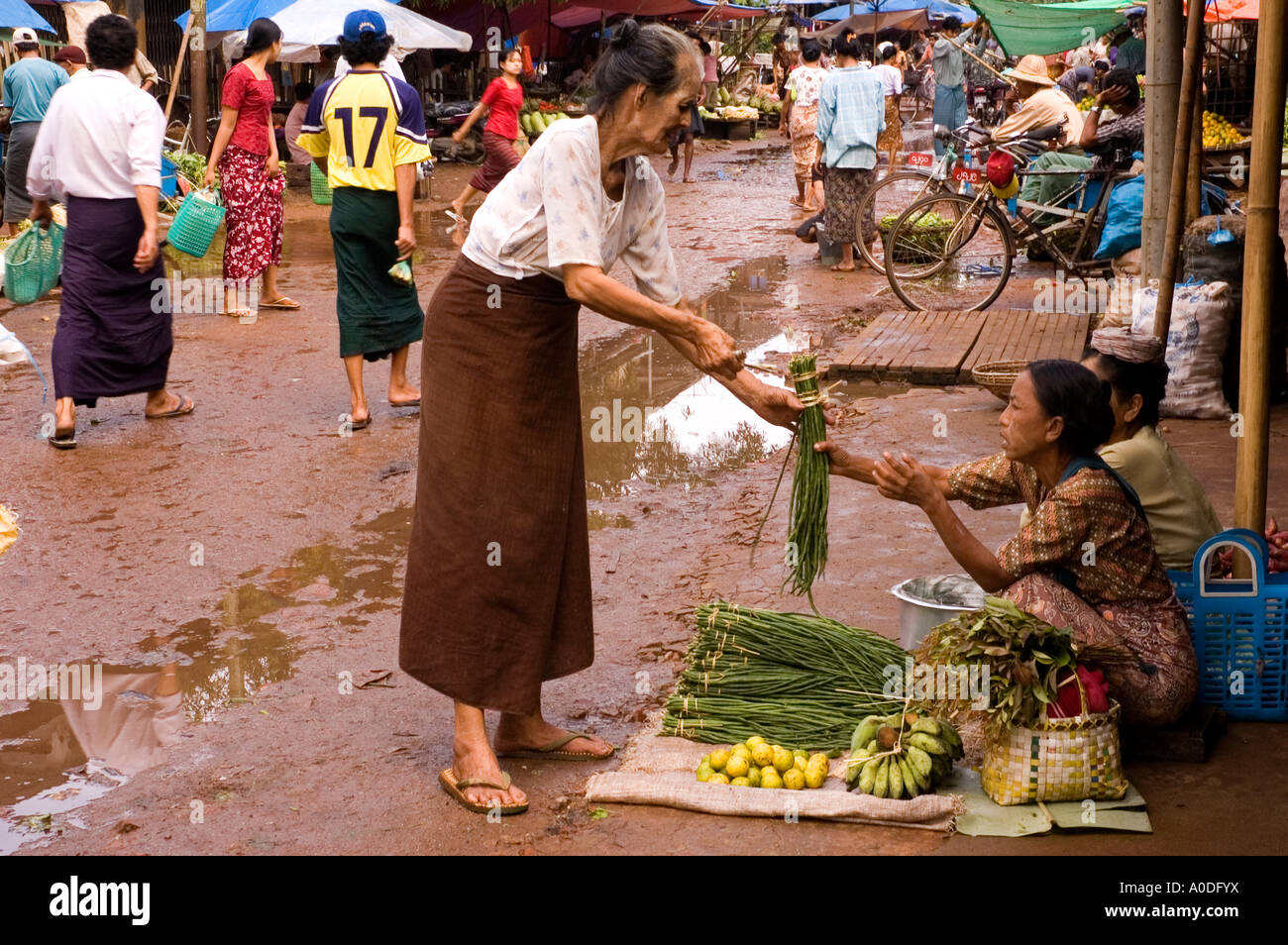 Photographie d'une vieille femme l'achat des haricots dans le marché à un jour pluvieux à Bago au Myanmar 2006 Banque D'Images