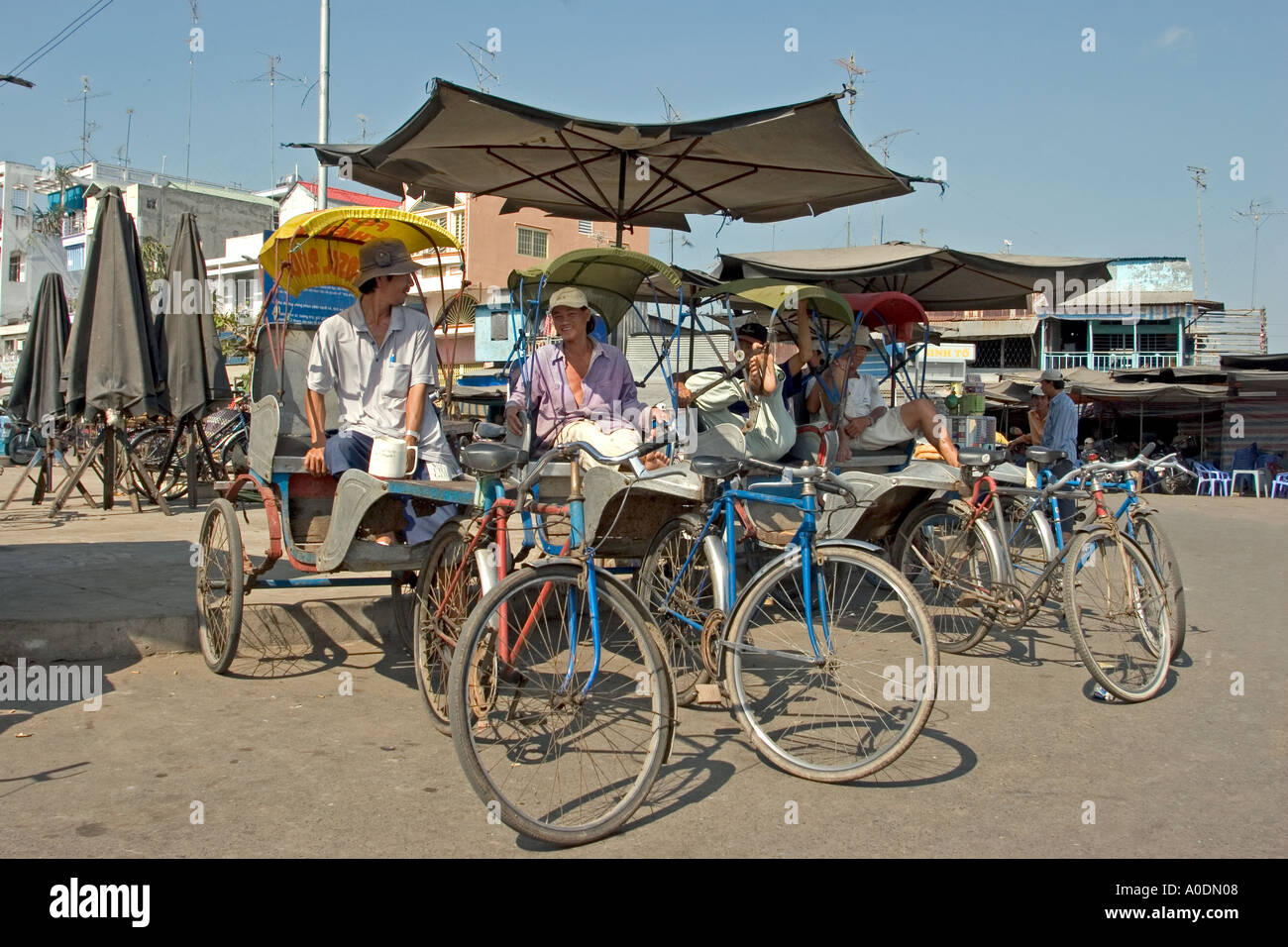 Delta du Mékong Vietnam Long Xuyen cycle cyclo transport les conducteurs de pousse-pousse le repos n'ombre d'un parasol Banque D'Images