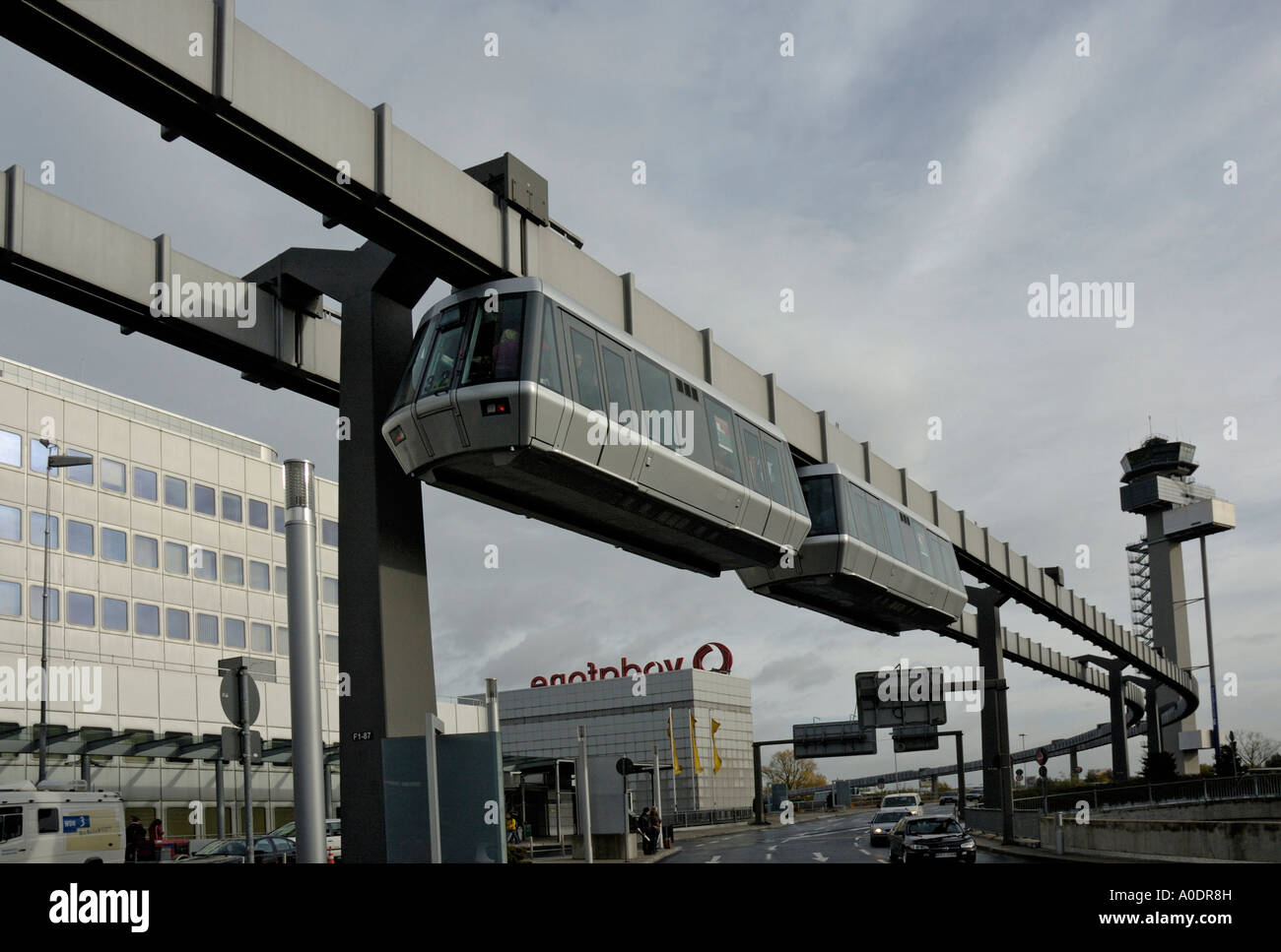 Le Skytrain, l'Aéroport International de Düsseldorf, Allemagne. L'aéroport de départ du vol avec tour de contrôle en arrière-plan. Banque D'Images